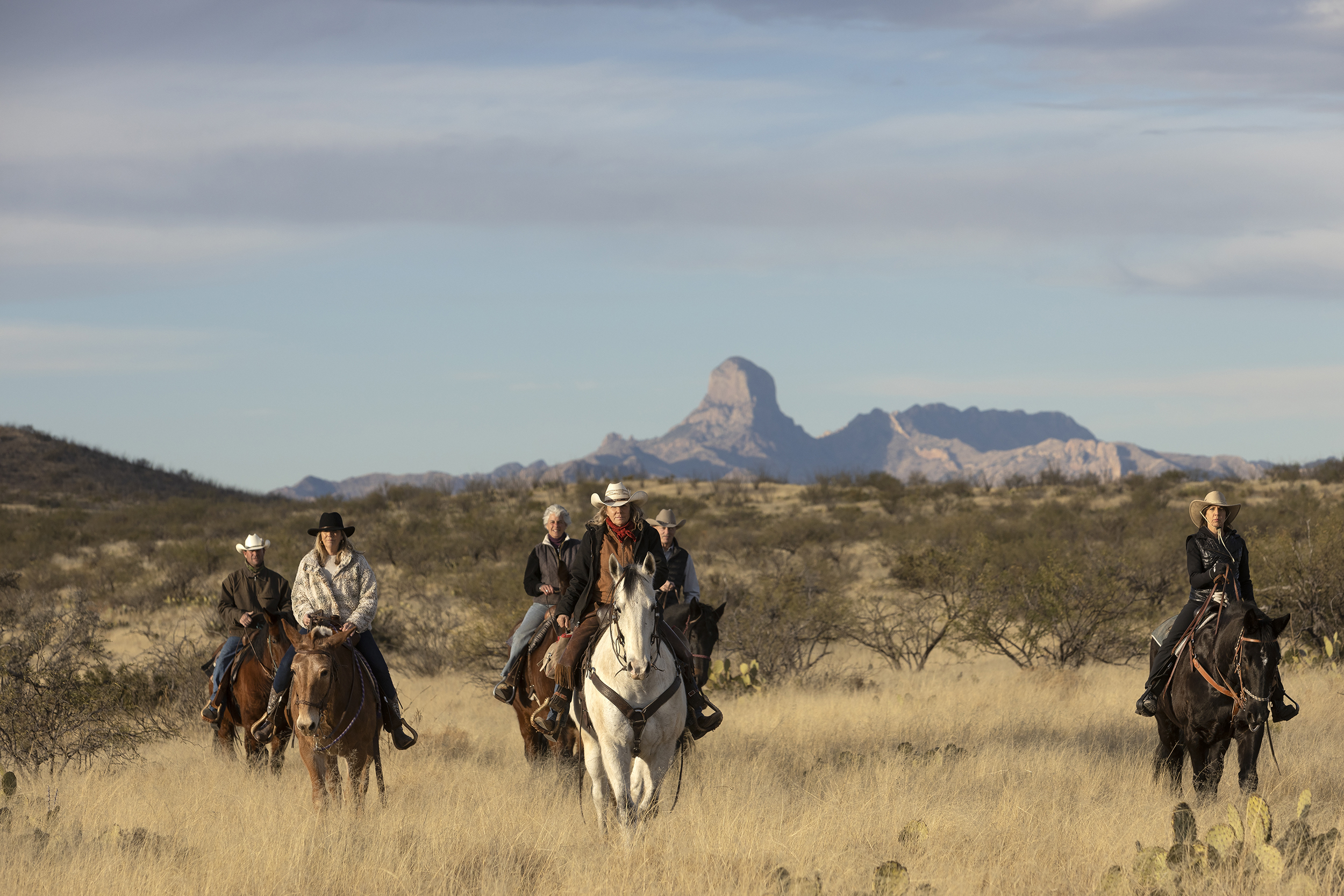 Riders in front of Baboquivari Peak during an Arizona dude ranch vacation at Rancho de la Osa.